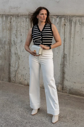 a lady wears a knitted vest with white jeans